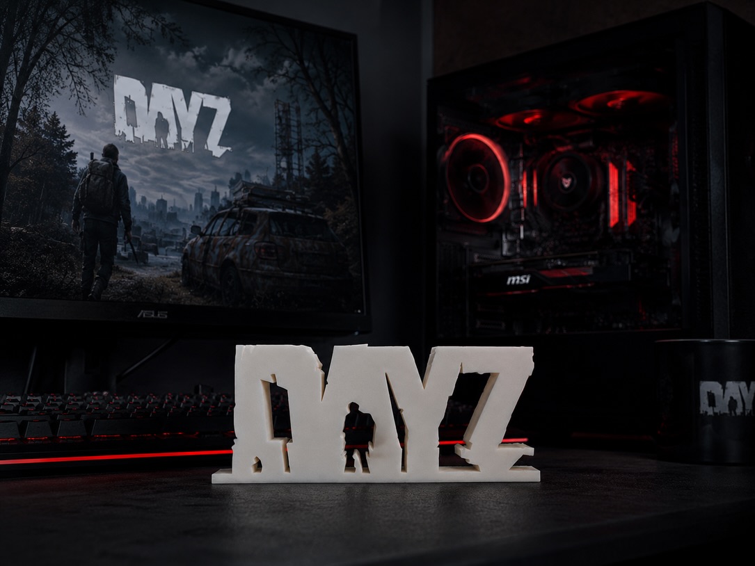 White freestanding 3D-printed gaming logo beside a desktop PC