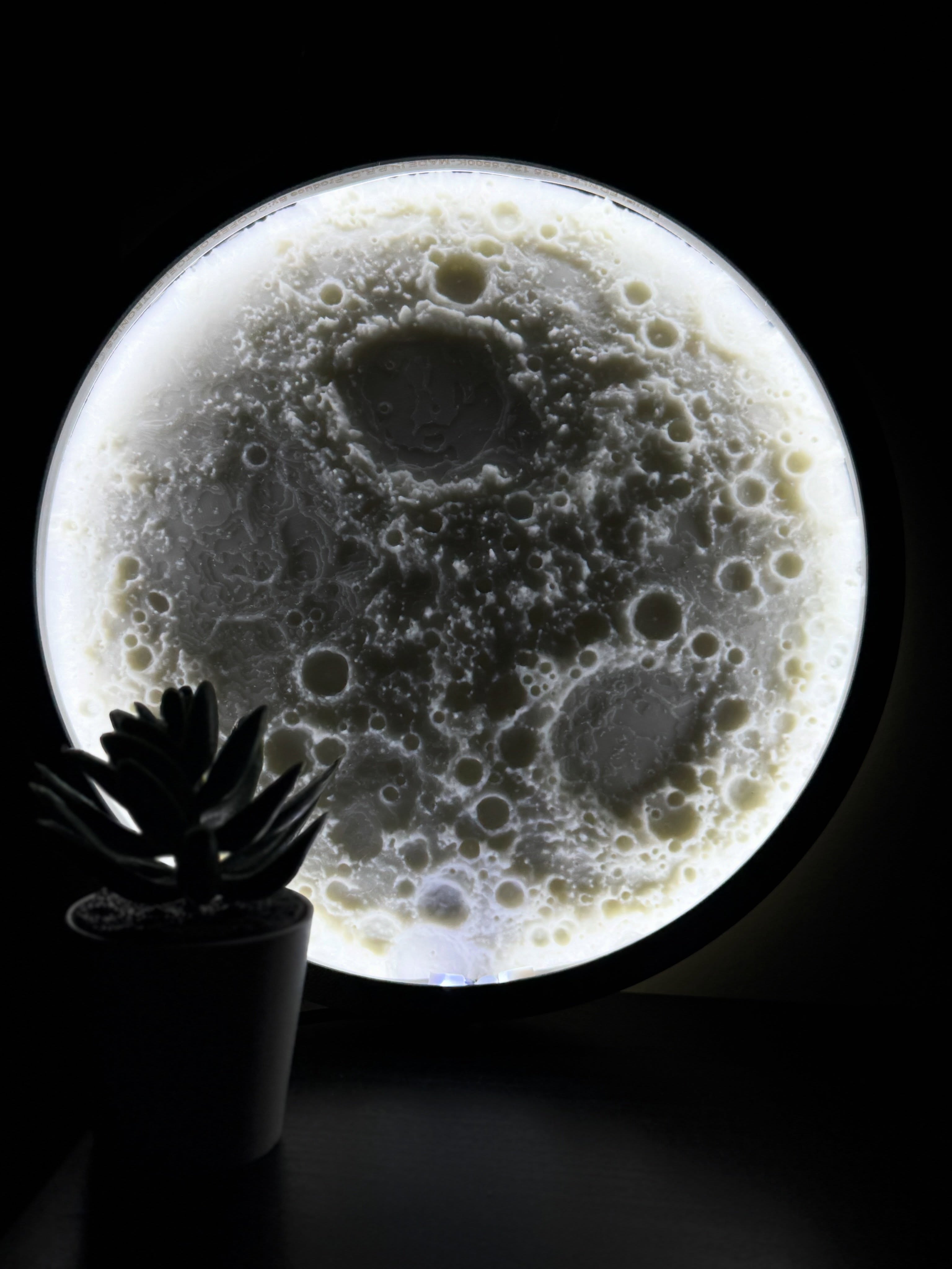 Illuminated textured moon lamp in a dark room